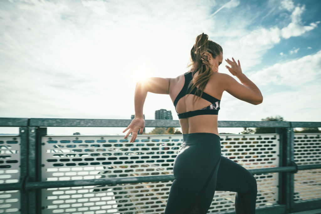 Woman Sprinting On Bridge