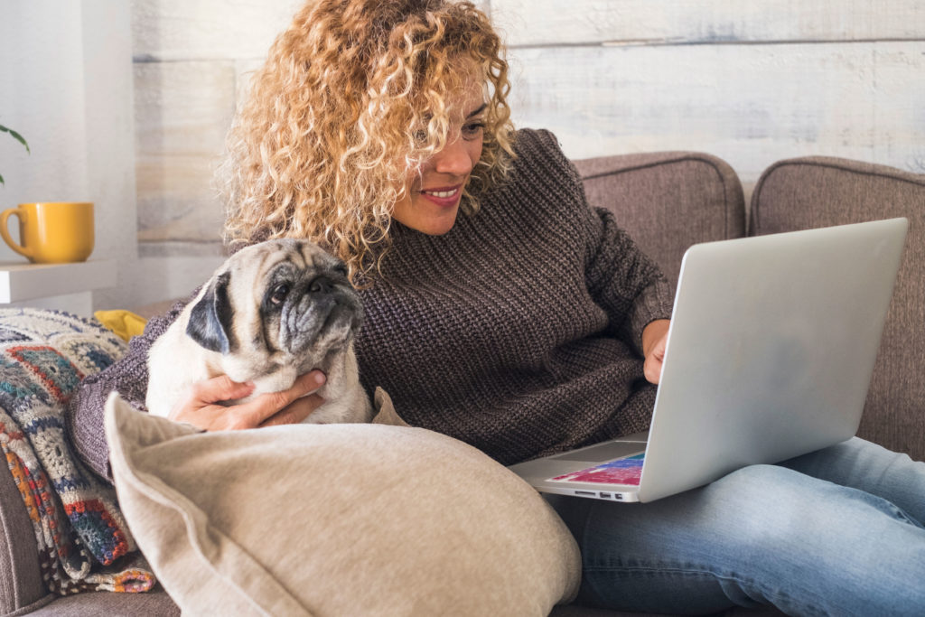 Woman Working On Computer With Dog