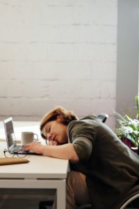 Woman Sleep Deprived At Work Sleeping On Her Laptop On Desk